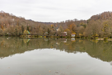 Fototapeta premium Lake with a reflection of a house and a few other houses in the background