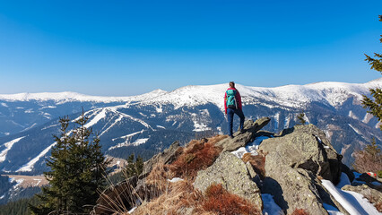Hiker woman pauses atop rocky Rappoldkogel in Stubalpe, Styria, Austria.Looking at scenic,...