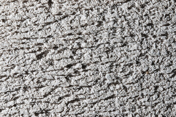 A wall with a rough texture and a white background