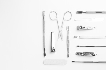 Set of pedicure tools on light background, flat lay. Space for text