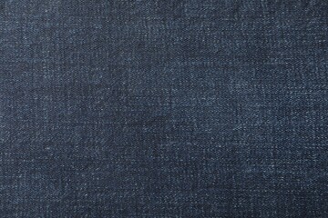 Texture of dark blue jeans as background, closeup