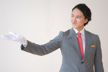 案内する白手袋をした男性