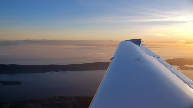 Wing of a Cirrus SR22 Airplane in Flight with a Beautiful Sunset Sky