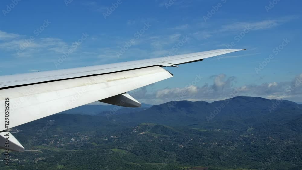 Poster passenger airplane wing with extended flaps - window view in flight