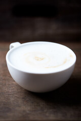 Cappuccino on dark wooden background. Soft focus. Close up.