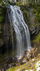 A stunning waterfall gracefully cascades over rocky cliffs, surrounded by lush greenery, capturing the dynamic beauty of nature and evoking a sense of tranquility and awe.