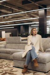 Stylish Woman Sitting on Sofa in Modern Interior Setting