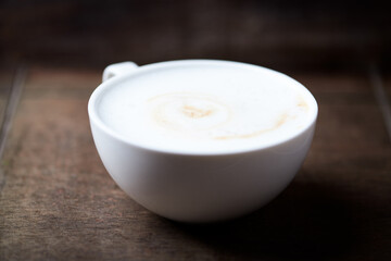 Cappuccino on dark wooden background. Soft focus. Close up.
