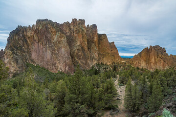 A breathtaking rock formation emerges dramatically from the surrounding landscape, showcasing nature's artistry and the vibrant colors of the rock against a clear sky.