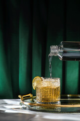 a glass of whiskey on the table is decorated with lemon