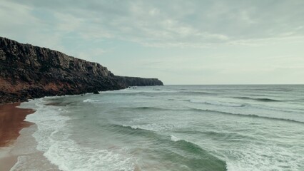 Sea waves wash the rocky mountains on the coast, a bird's-eye view from the sea
