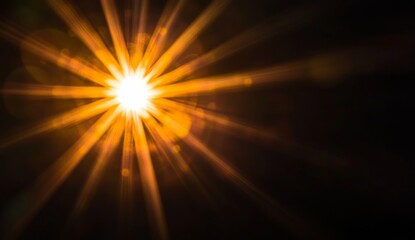 Obraz premium Intense sunburst lens flare on dark background