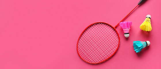Badminton racket and shuttlecocks on color background
