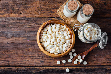 Milk tablets on wooden background