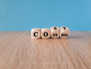 Cost control symbol. Turned wooden cubes and changes the concept word Cost to Control. Beautiful wooden table blue background. Business cost control concept.