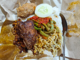 Nasi campur (Nasi Rames) is a typical Javanese Indonesian dish, which consists of white rice served with various side dishes.