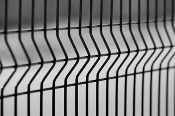metal fence made of 3d mesh panels close-up on a gray background