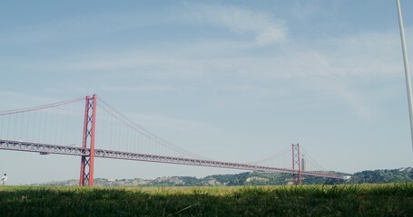 Fototapeta premium Red suspension bridge in Portugal, view of the Statue of Christ in Almada, Portugal