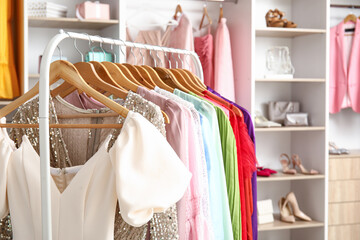 Rack with beautiful prom dresses in boutique, closeup