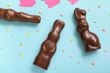 Chocolate Easter bunnies and sprinkles on blue background
