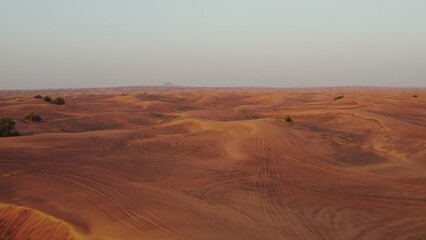 A bright red desert. Sand dunes from a bird's-eye view. Contrasting view of the sand with the sky
