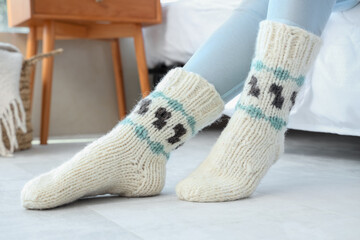 Woman in warm socks on floor with heating at home, closeup