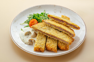 baked breaded meat fillet with sauce
