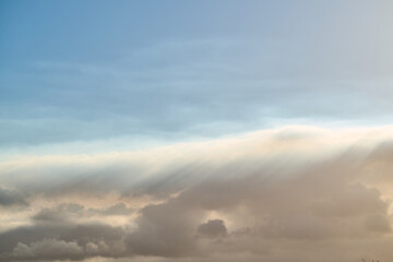 Sunbeams filtering through clouds in blue sky