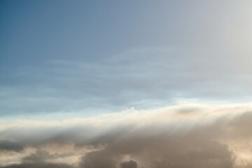 Obraz premium Sunlight filtering through clouds in blue sky