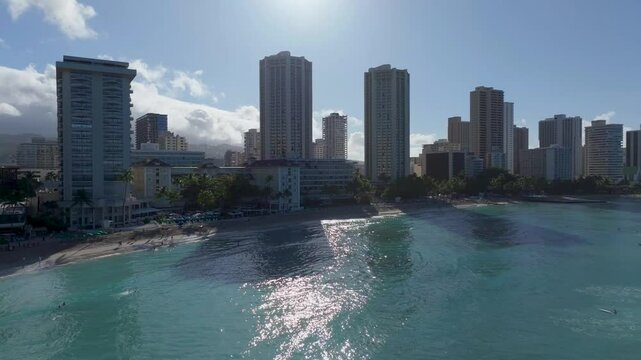 Panning aerial Waikiki Beach high rise buildings and surf