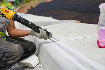 Detailed shot of filling gaps between road curbs and concrete highway for long-lasting seal