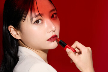 Obraz premium 赤い口紅のメイクアップをした若い女性のシックなポートレート