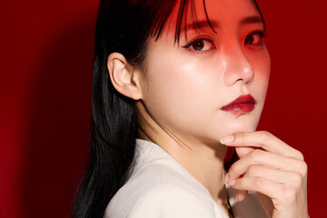 赤い口紅のメイクアップをした若い女性のシックなポートレート
