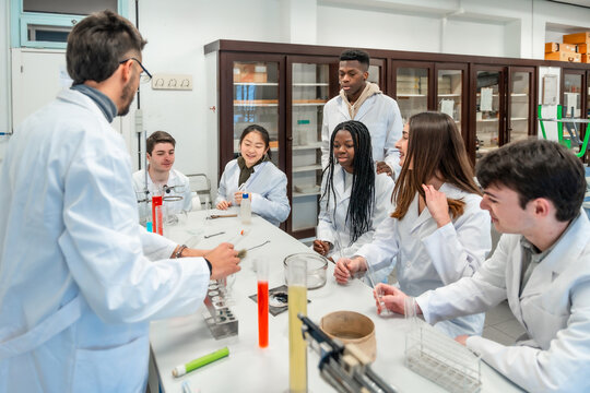 Chemistry teacher explaining experiment to students in university laboratory