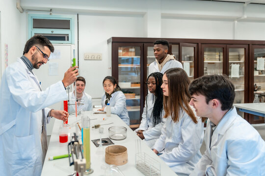 Chemistry teacher making experiment with students in university lab