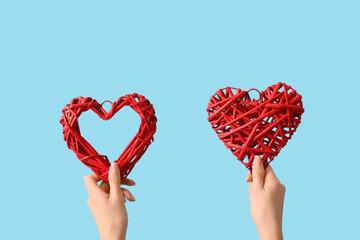 Female hands with hearts on blue background. Valentine's Day celebration