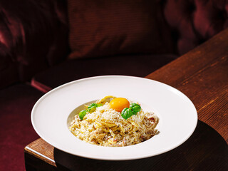 Delicious pasta dish with egg yolk and herbs served in a restaurant