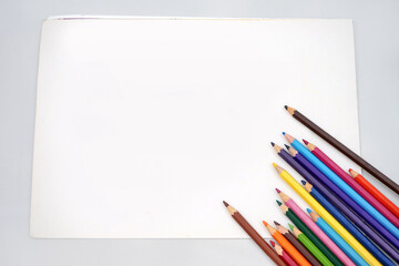 Studio shot of flatlay photo of kids coloring pencils on white paper background banner, copy space. Back to school concept.	