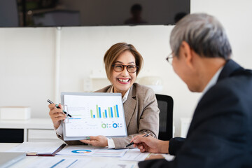 Male and female coworkers discussing while sitting at desk in creative office .Meeting, teamwork, successful business