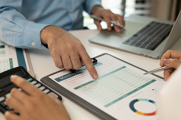 A man and a woman are looking at a piece of paper with graphs on it. They are discussing the data and making decisions based on it
