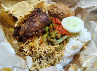 Nasi campur (Nasi Rames) is a typical Javanese Indonesian dish, which consists of white rice served with various side dishes.