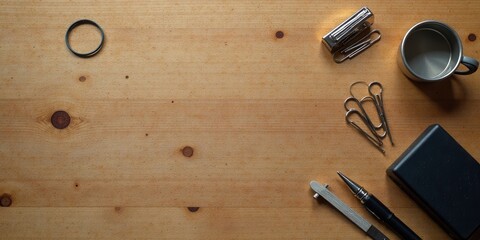 A Simple Workspace Featuring a Wooden Surface, Office Supplies, and a Metal Mug