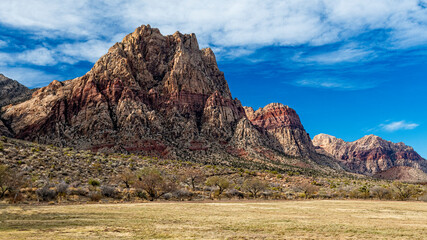 Dramatic mountain peaks rise majestically against a vibrant blue sky, showcasing the majestic beauty of nature and the allure of outdoor exploration in raw landscapes.