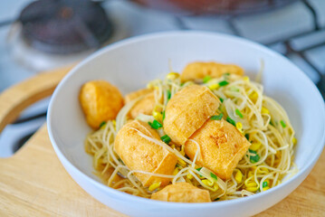 Healthy Thai vegan food, stir-fried Mung bean sprouts with deep-fried tofu. Homemade healthy meal, natural light.