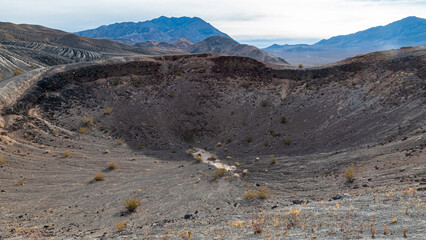 An impressive impact crater reveals the raw power of nature, surrounded by a rugged mountain landscape, showcasing geological history and the beauty of Earth's surface design.