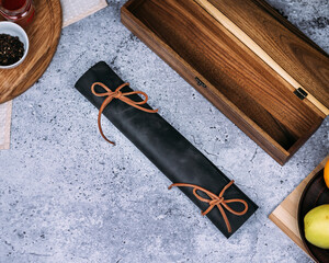 A knife with a polished, dark reddish-brown wooden handle and a sleek metal blade rests on a...