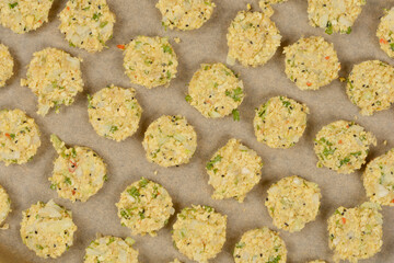 A top-down shot of raw soy patties arranged on parchment paper, ready for baking, showcasing their textured surface and visible ingredients