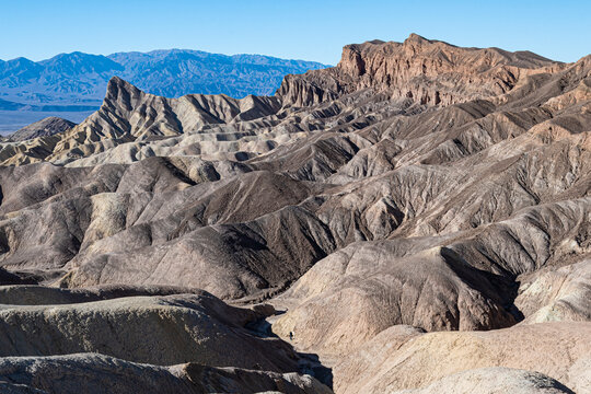 An awe-inspiring view of rugged mountains adorned in earthy tones captures the raw beauty of nature&rsquo;s geological formations and their intricate patterns.