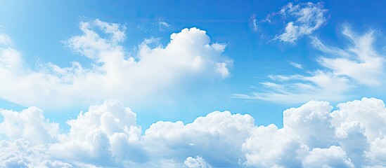 Fluffy white clouds scattered across a bright azure sky with a seamless blue gradient creating a serene and tranquil atmosphere.