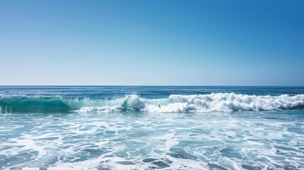Fototapeta premium A lone surfer catching a wave under a clear blue sky with